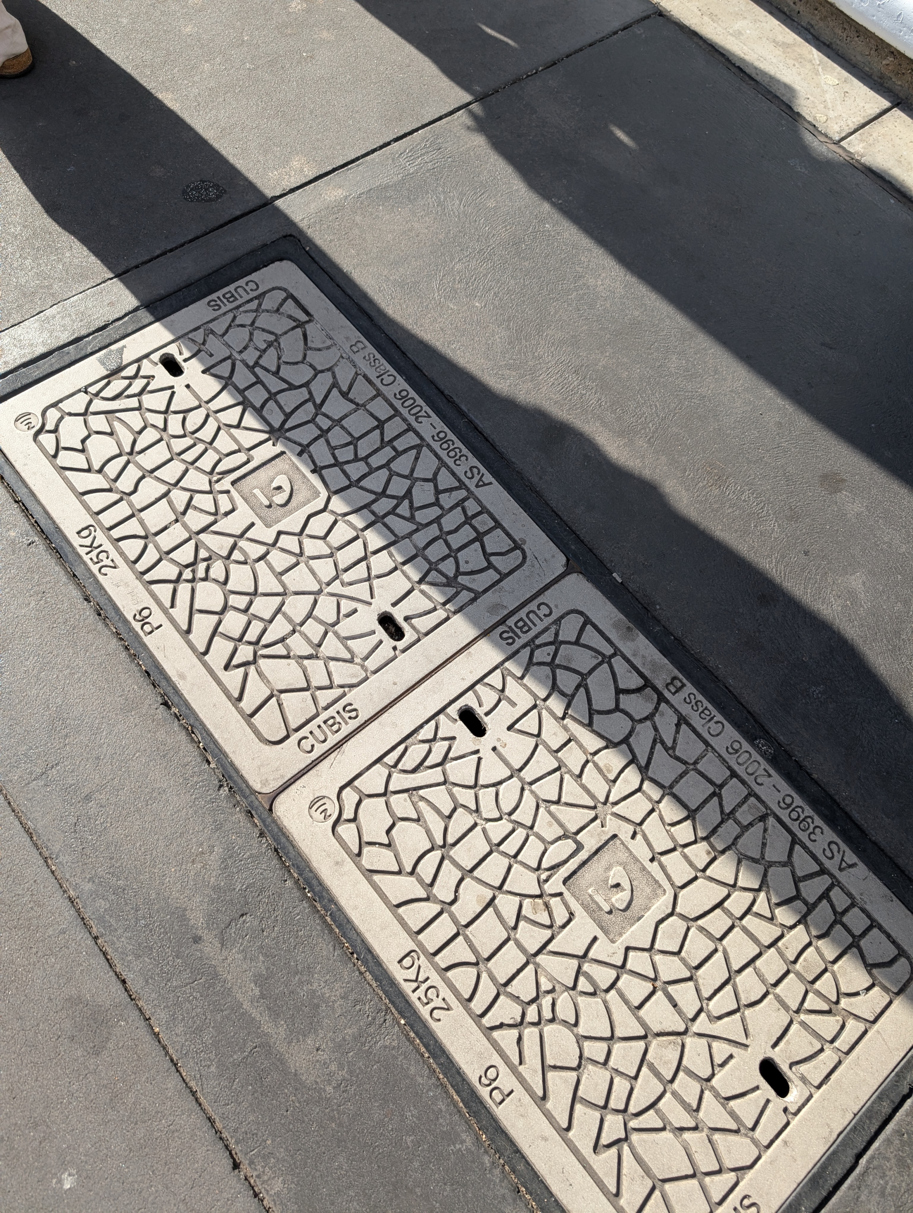 Two telecommunications pit lids in street environment with deployed tags